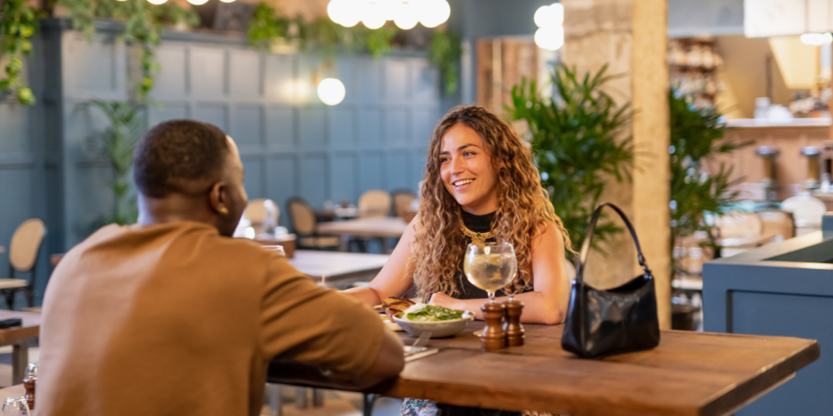 Couple sat opening presents in restaurant