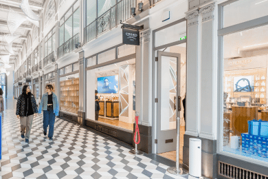 Two people walking along arcade corridor 