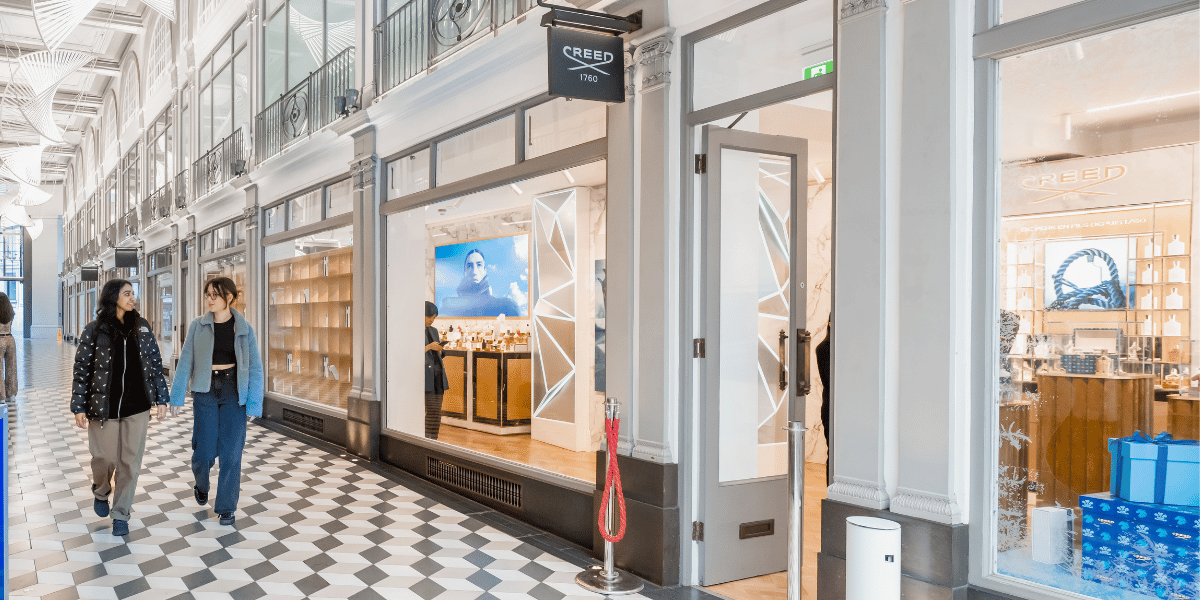 Two people walking along arcade corridor 